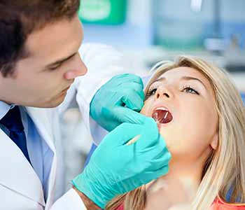 Image of a dentist checking patients's mouth